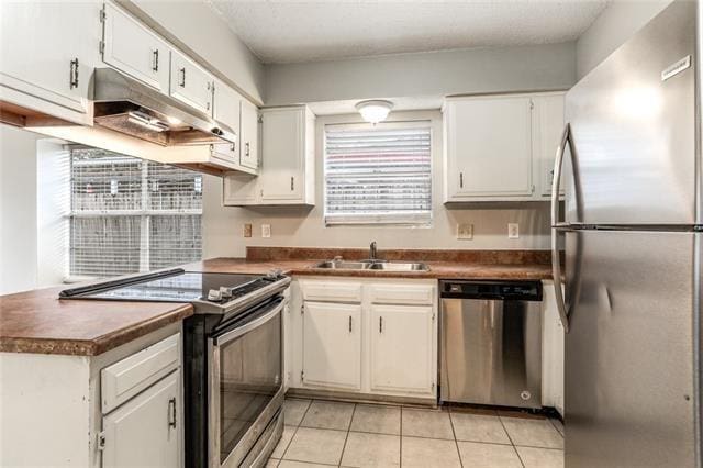 kitchen with white cabinets, light tile patterned floors, and appliances with stainless steel finishes