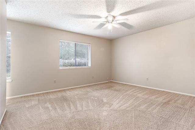 empty room with light carpet, a textured ceiling, and ceiling fan