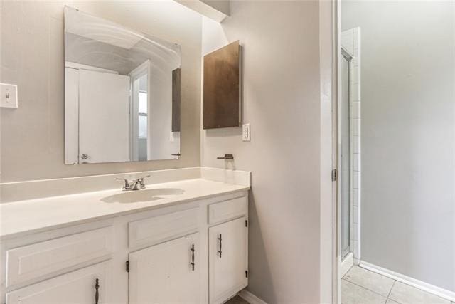 bathroom featuring tile patterned flooring, vanity, and an enclosed shower