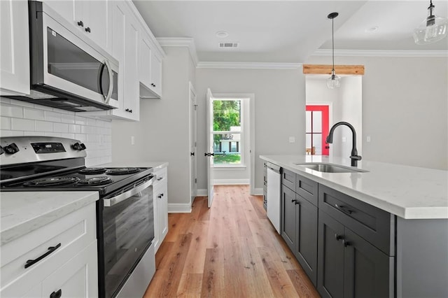 kitchen featuring pendant lighting, sink, stainless steel appliances, and white cabinets