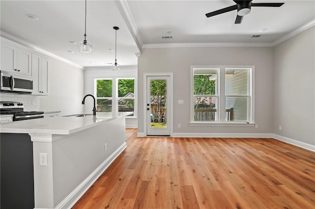 kitchen with white cabinetry, stainless steel appliances, decorative light fixtures, and crown molding