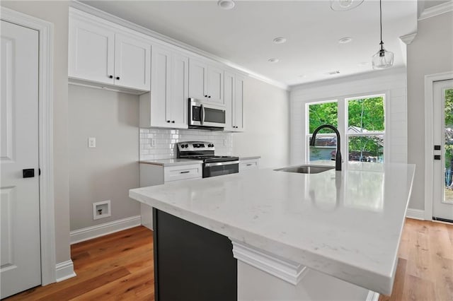 kitchen with white cabinetry, a center island with sink, and appliances with stainless steel finishes