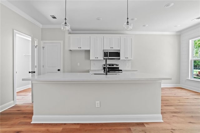 kitchen with white cabinetry, hanging light fixtures, an island with sink, and appliances with stainless steel finishes