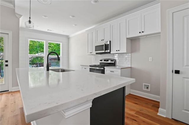 kitchen featuring white cabinetry, stainless steel appliances, sink, and a center island with sink