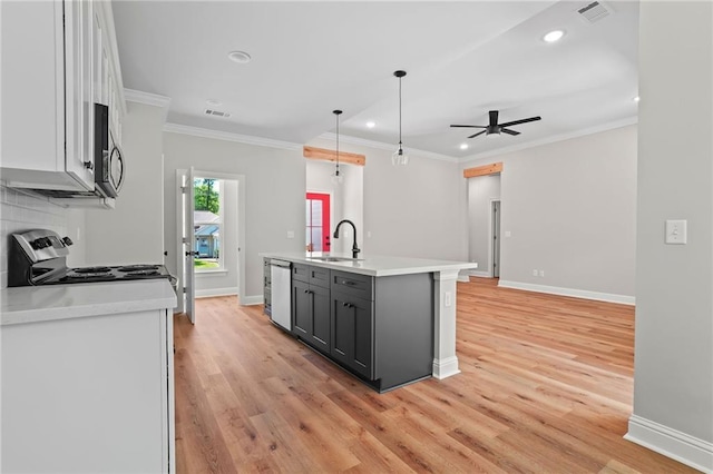 kitchen featuring sink, white cabinetry, decorative light fixtures, an island with sink, and stainless steel appliances