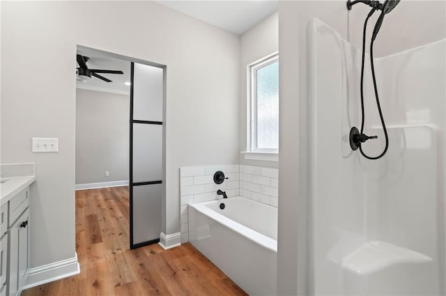 bathroom featuring hardwood / wood-style flooring, ceiling fan, vanity, and a tub