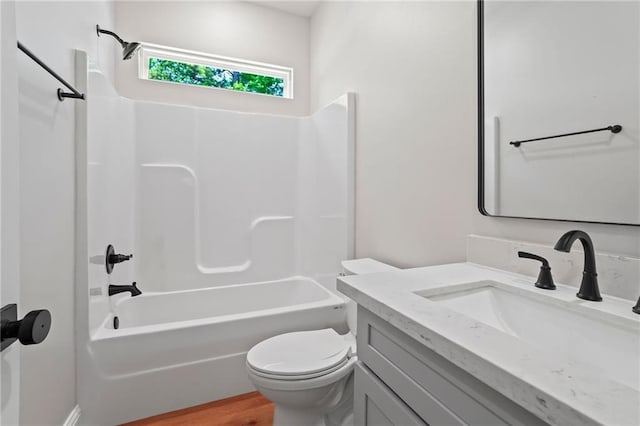 full bathroom with toilet, vanity, bathtub / shower combination, and hardwood / wood-style flooring