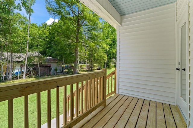 wooden terrace featuring a yard