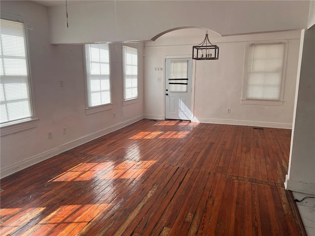 3633 Franklin Ave, New Orleans, LA 70122 - unfurnished dining area featuring hardwood / wood-style flooring, baseboards, and arched walkways