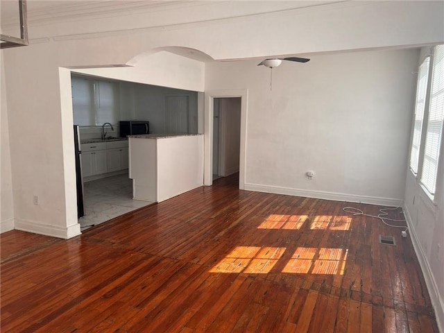 3633 Franklin Ave, New Orleans, LA 70122 - spare room with hardwood / wood-style floors, arched walkways, baseboards, and a sink