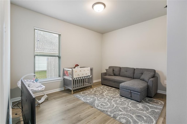 bedroom with hardwood / wood-style flooring and a crib