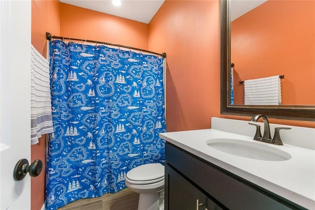 bathroom featuring hardwood / wood-style floors, a shower with shower curtain, vanity, and toilet