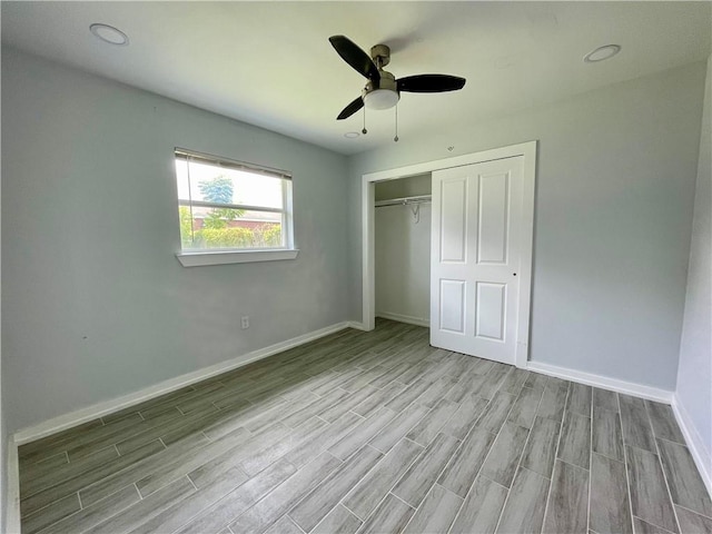 unfurnished bedroom with ceiling fan, a closet, and light wood-type flooring