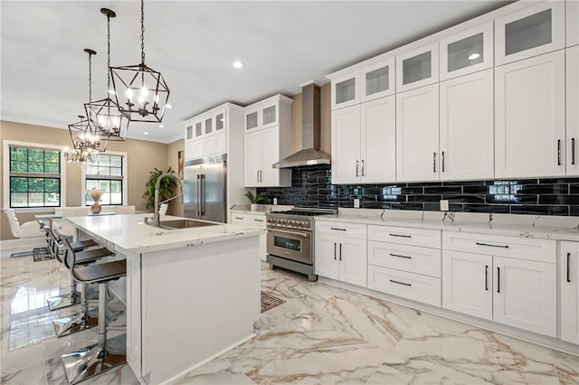 kitchen featuring backsplash, high quality appliances, marble finish floor, and wall chimney exhaust hood