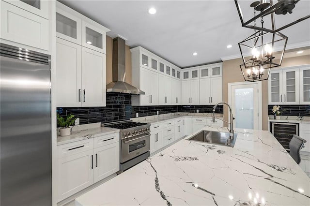 kitchen with a sink, wall chimney exhaust hood, premium appliances, wine cooler, and recessed lighting