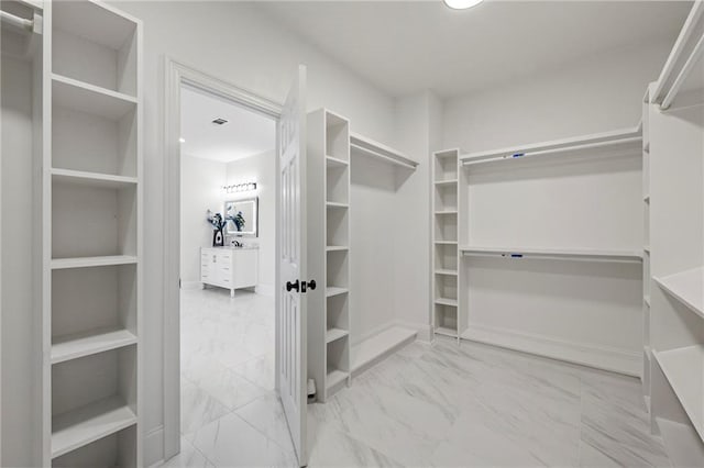 spacious closet featuring marble finish floor