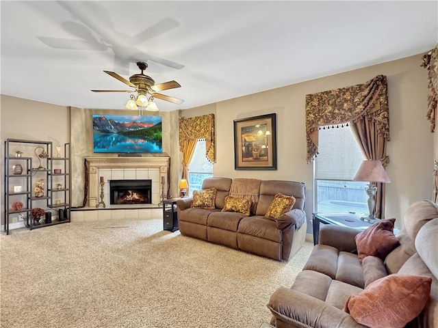 carpeted living room with a fireplace and ceiling fan