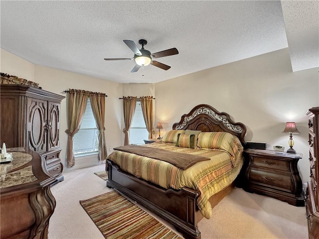 bedroom with ceiling fan, a textured ceiling, and light carpet