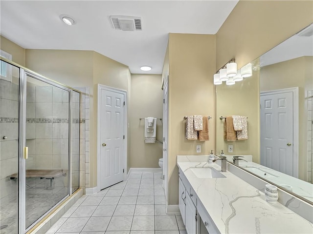 bathroom with tile patterned flooring, vanity, toilet, and a shower with shower door