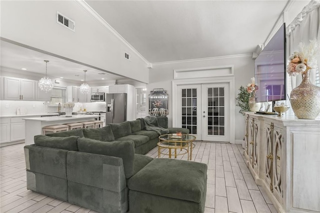 living room featuring sink, french doors, ornamental molding, and light hardwood / wood-style flooring