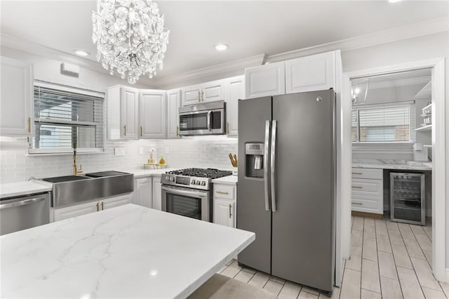 kitchen with wine cooler, white cabinets, a healthy amount of sunlight, and stainless steel appliances