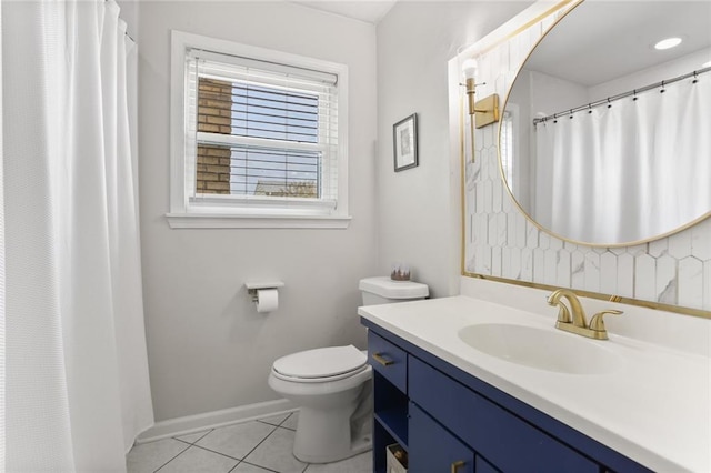 bathroom with toilet, vanity, and tile patterned flooring