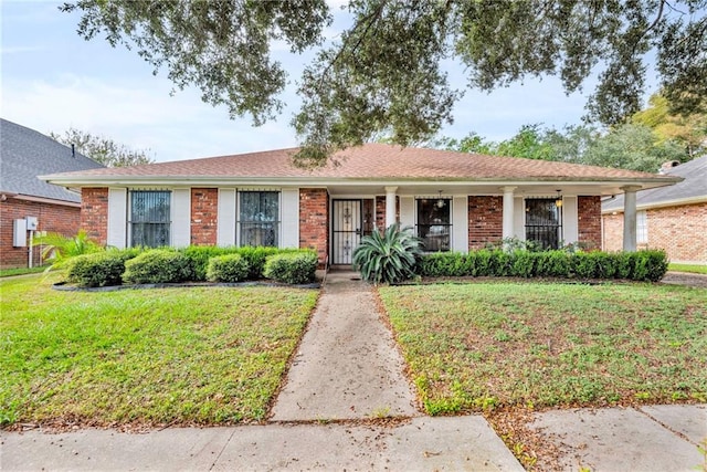 ranch-style home with covered porch and a front yard