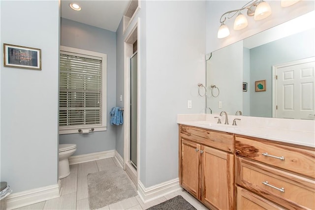 bathroom featuring toilet, vanity, and a shower with door