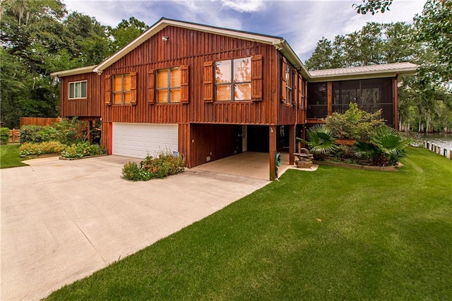 view of front of home with a front lawn, a garage, and a sunroom