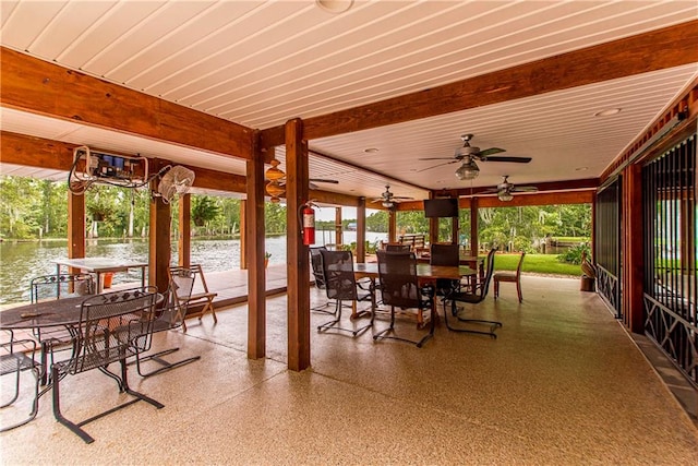 view of patio with a water view and ceiling fan