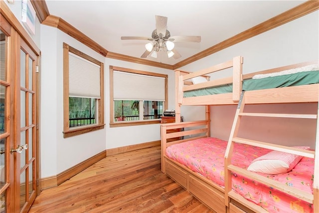 bedroom featuring hardwood / wood-style floors, ceiling fan, and crown molding