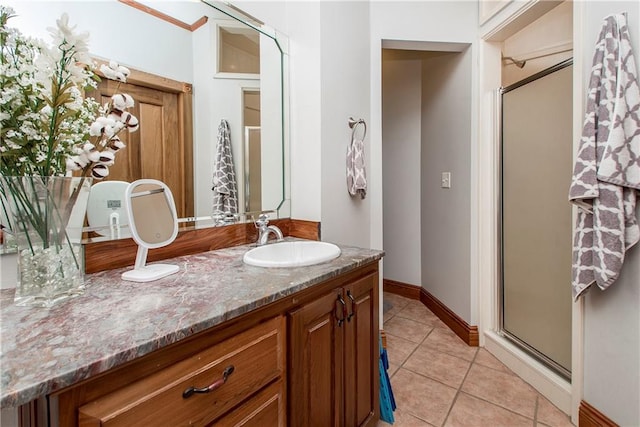 bathroom featuring vanity, a shower with shower door, and tile patterned floors