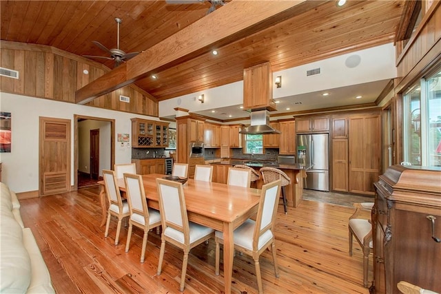 dining area with beamed ceiling, ceiling fan, light wood-type flooring, and high vaulted ceiling