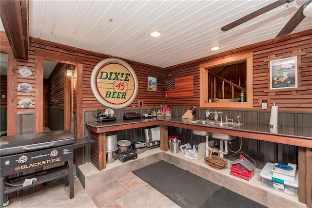 interior space with wood walls, wooden ceiling, and sink