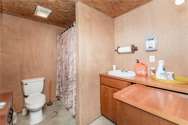 bathroom with concrete flooring, vanity, and toilet