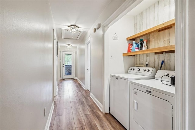 laundry area with separate washer and dryer, light wood finished floors, baseboards, attic access, and laundry area