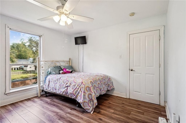 bedroom with baseboards, wood finished floors, and a ceiling fan