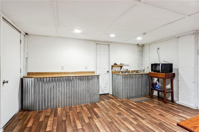 bar featuring wood finished floors and black microwave