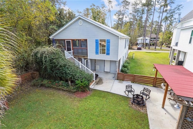 rear view of property with a patio, a lawn, stairs, and fence