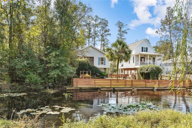 rear view of house featuring a water view and a fenced front yard