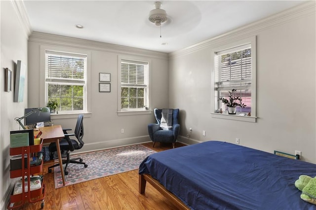 bedroom featuring hardwood / wood-style flooring, ceiling fan, and crown molding