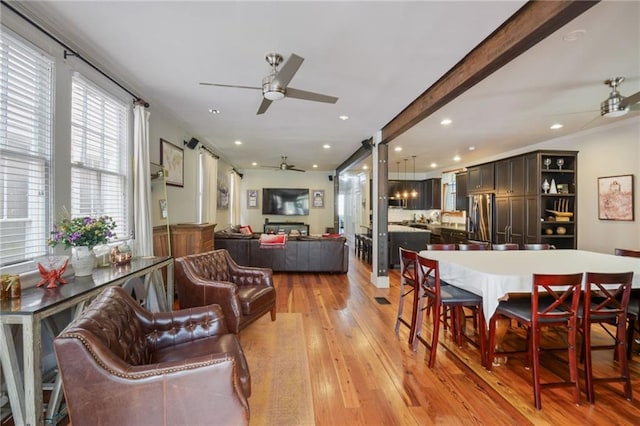 dining area featuring light hardwood / wood-style floors, ceiling fan, and beam ceiling