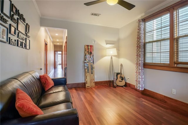 living room with ceiling fan, wood-type flooring, and ornamental molding