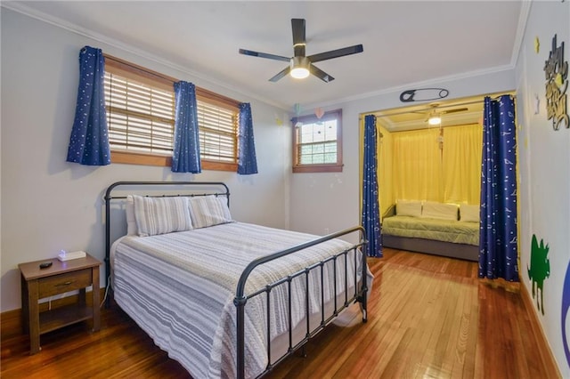 bedroom with wood-type flooring, ceiling fan, and crown molding