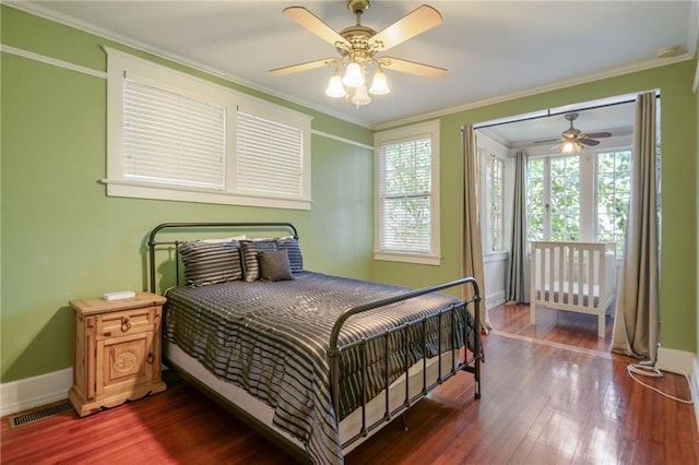 bedroom with ceiling fan, dark hardwood / wood-style flooring, and ornamental molding