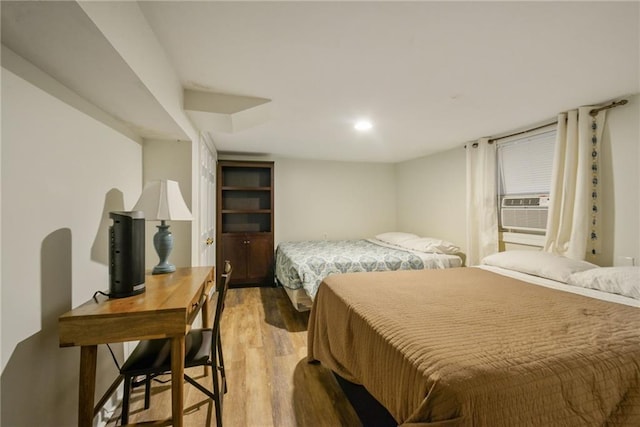 bedroom with cooling unit and light hardwood / wood-style floors