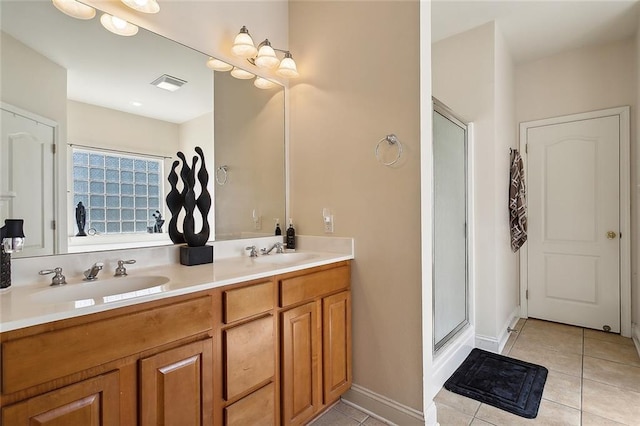 bathroom with tile patterned flooring, vanity, and a shower with door