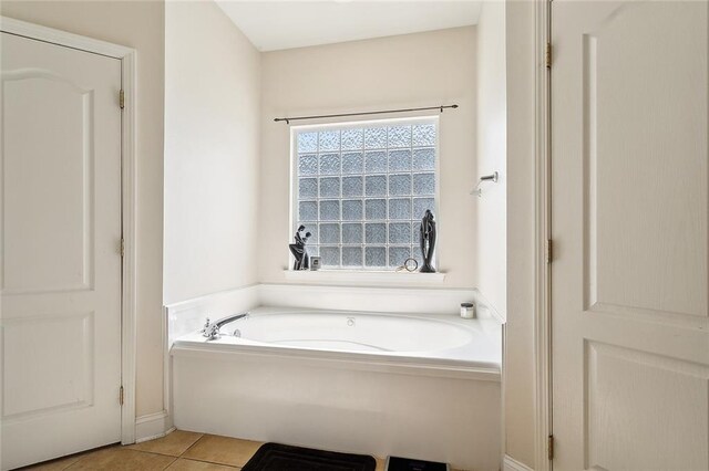 bathroom with tile patterned flooring and a tub to relax in