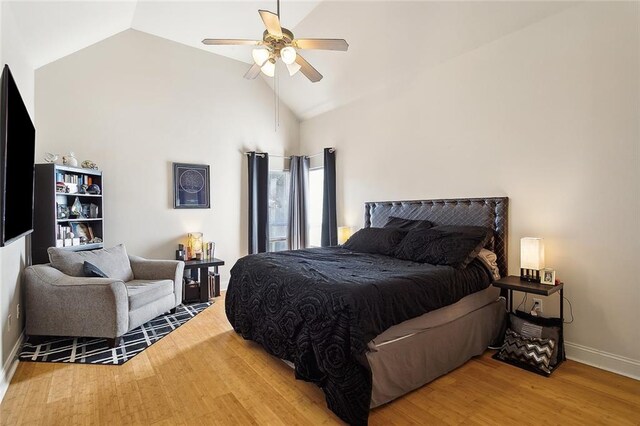 bedroom with hardwood / wood-style flooring, high vaulted ceiling, and ceiling fan