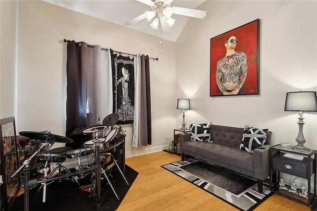 living room with ceiling fan, hardwood / wood-style floors, and vaulted ceiling